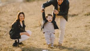Family enjoying playful soccer game outdoors, capturing joyful moments.